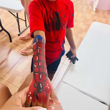 Criança com pintura do Spiderman no braço